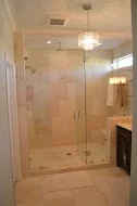Frameless glass shower with marble tile walls and heated floor in modern bathroom