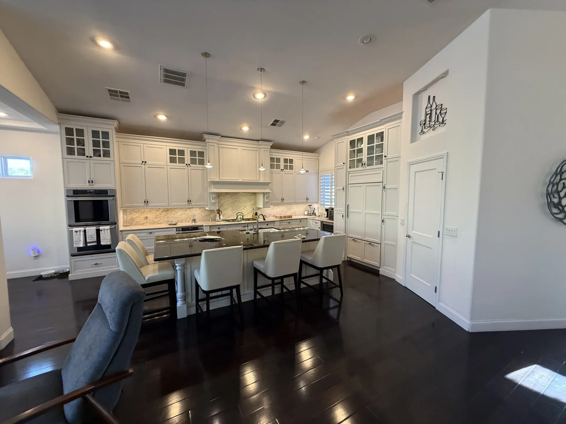 Cream cabinetry kitchen with granite counters, island seating, and stainless steel appliances
