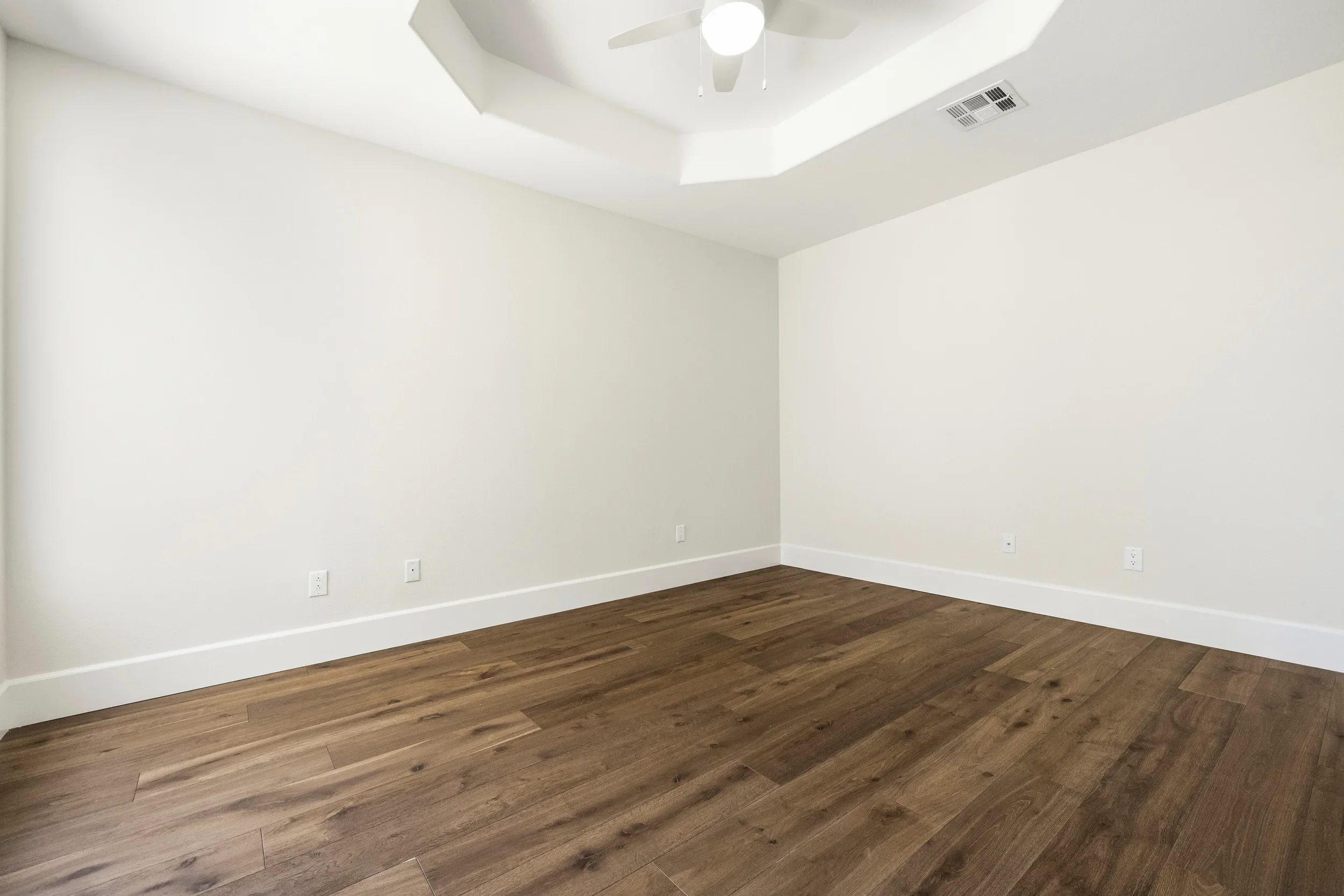 Master bedroom with coffered ceiling, hardwood flooring, and white trim