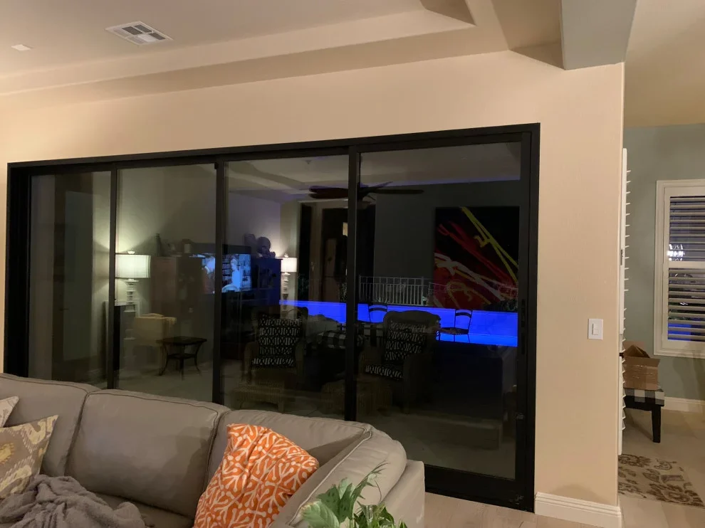 Four-panel black aluminum sliding glass doors with clear glass panes in residential interior