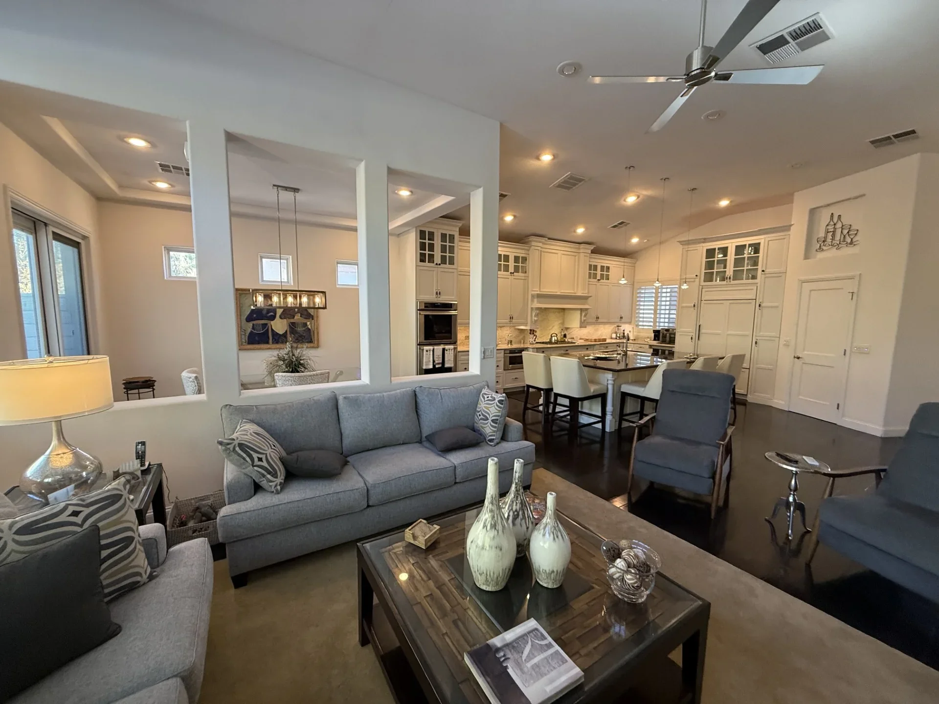 Open-concept living room and kitchen with cream cabinetry, island, recessed lighting, and hardwood floors