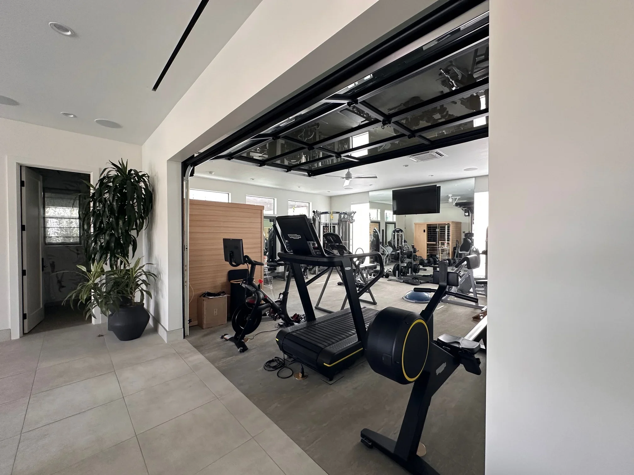 Home gym with glass garage door, concrete floor, recessed lighting, and exercise equipment