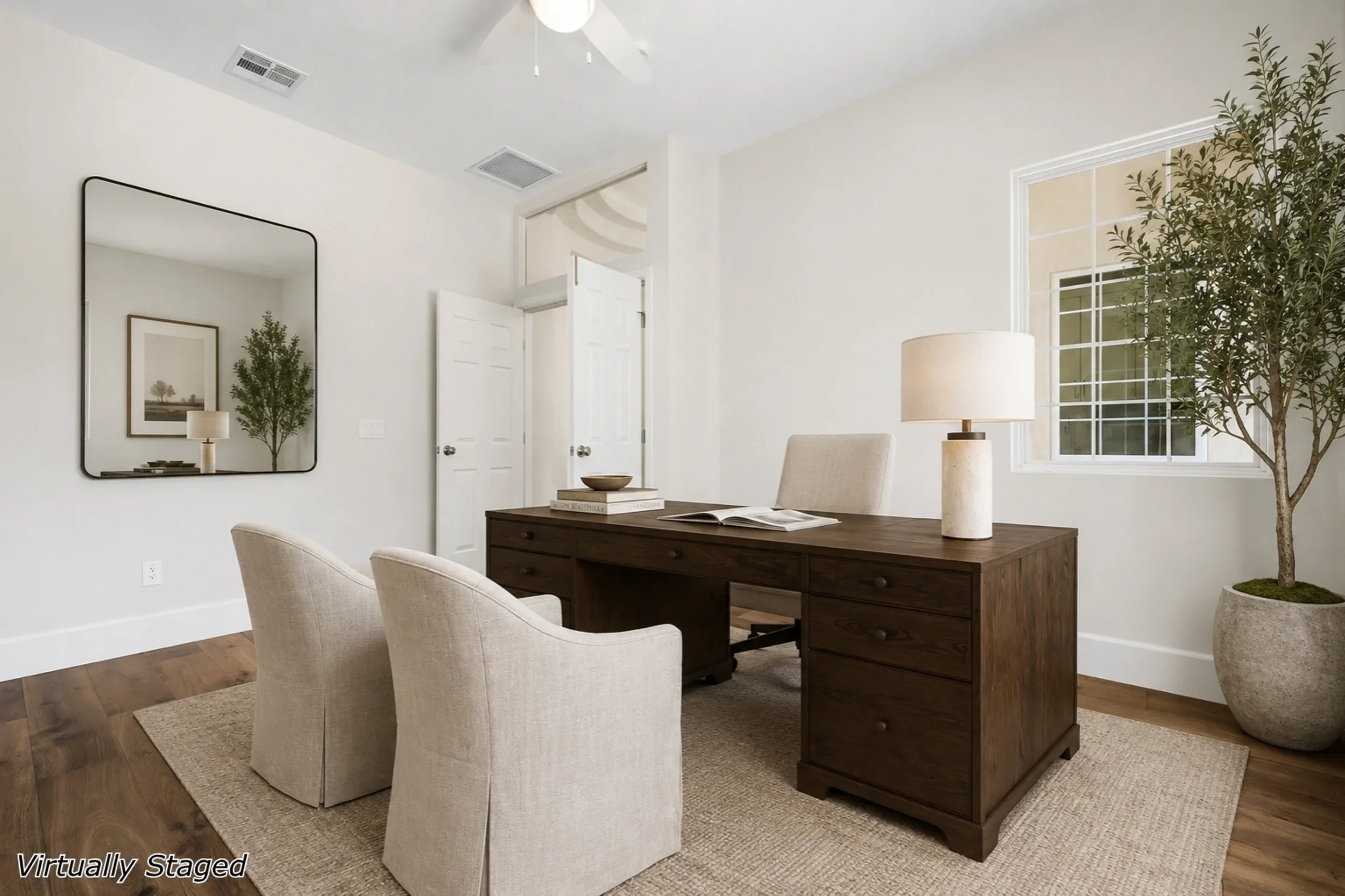 Modern home office with hardwood floors, white walls, dark wood desk, and recessed lighting