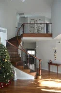 Custom wooden staircase with spindle railings and second-floor landing installation