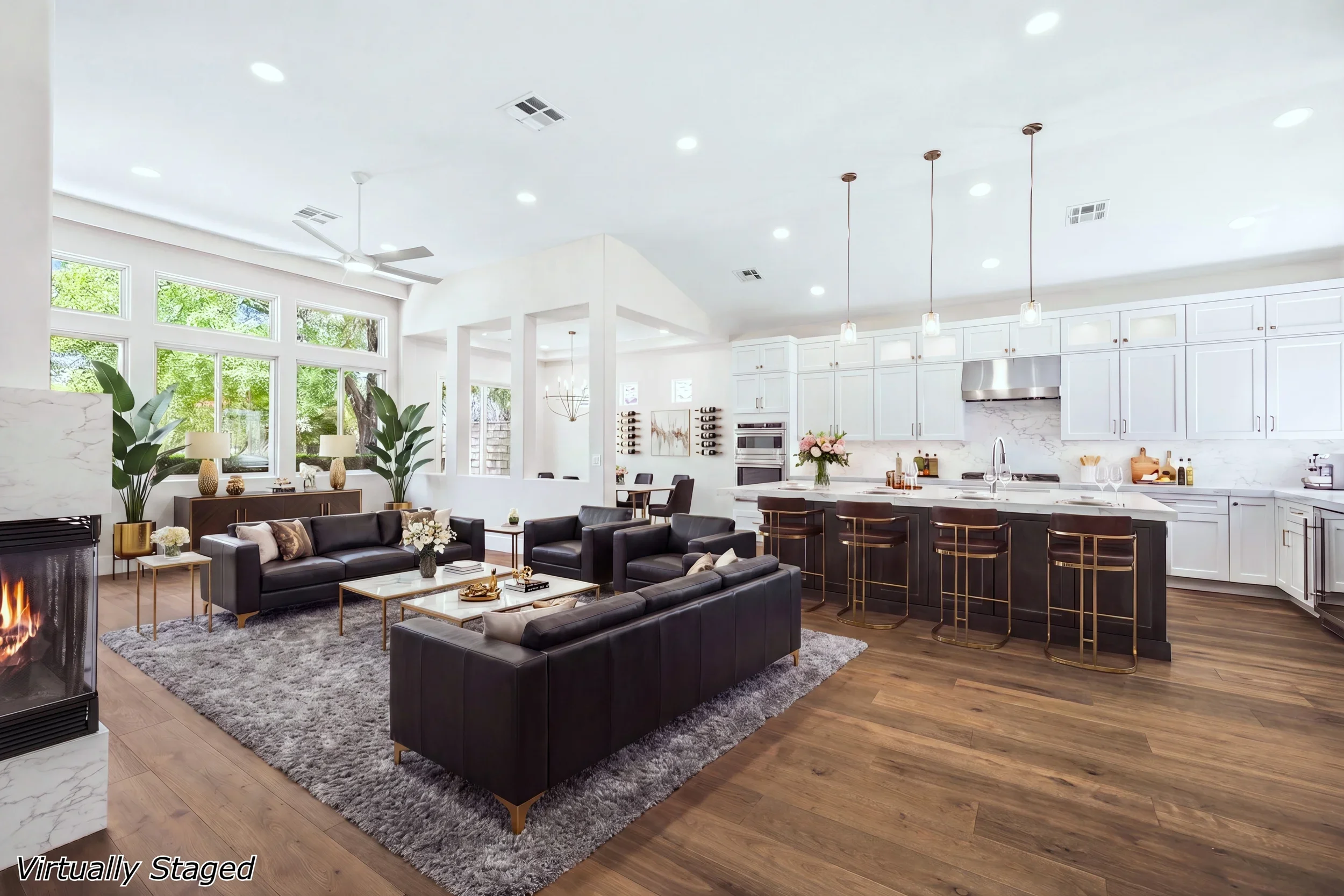 Open concept kitchen and living room with white cabinetry, dark wood island, hardwood floors, and fireplace