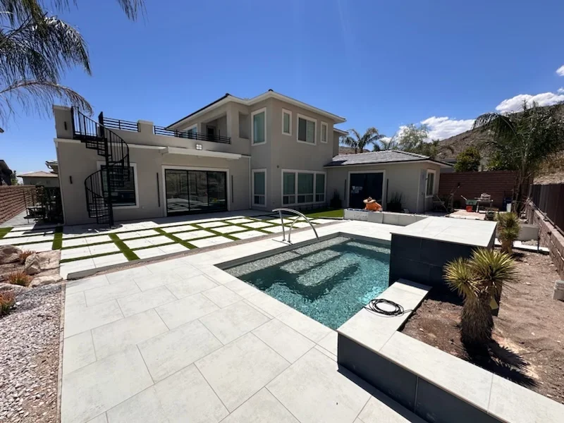 Light-colored paver patio with pool, spa, and modern hardscape landscaping