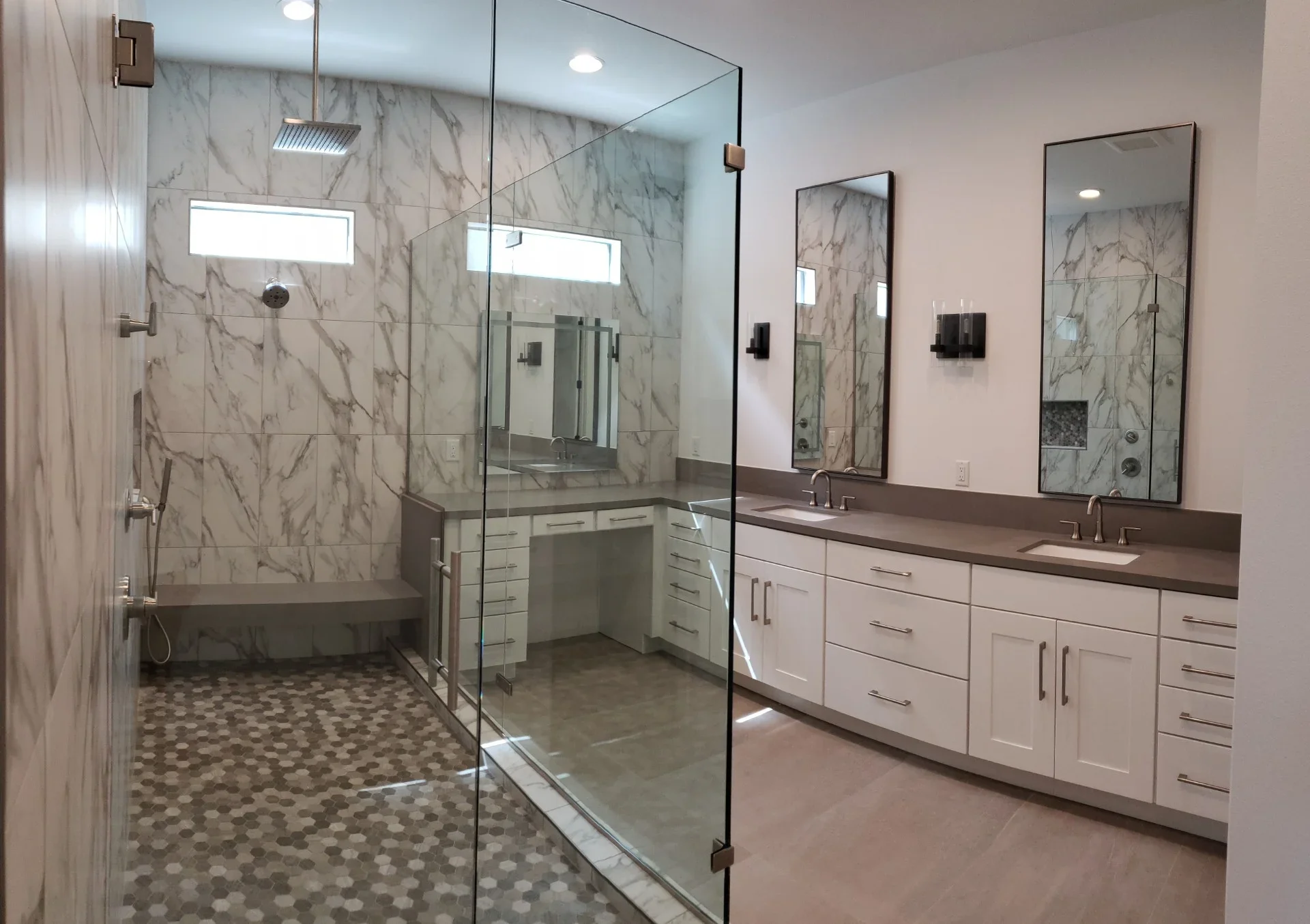 Master bathroom with marble tile shower, dual vanity, and hexagonal floor tile