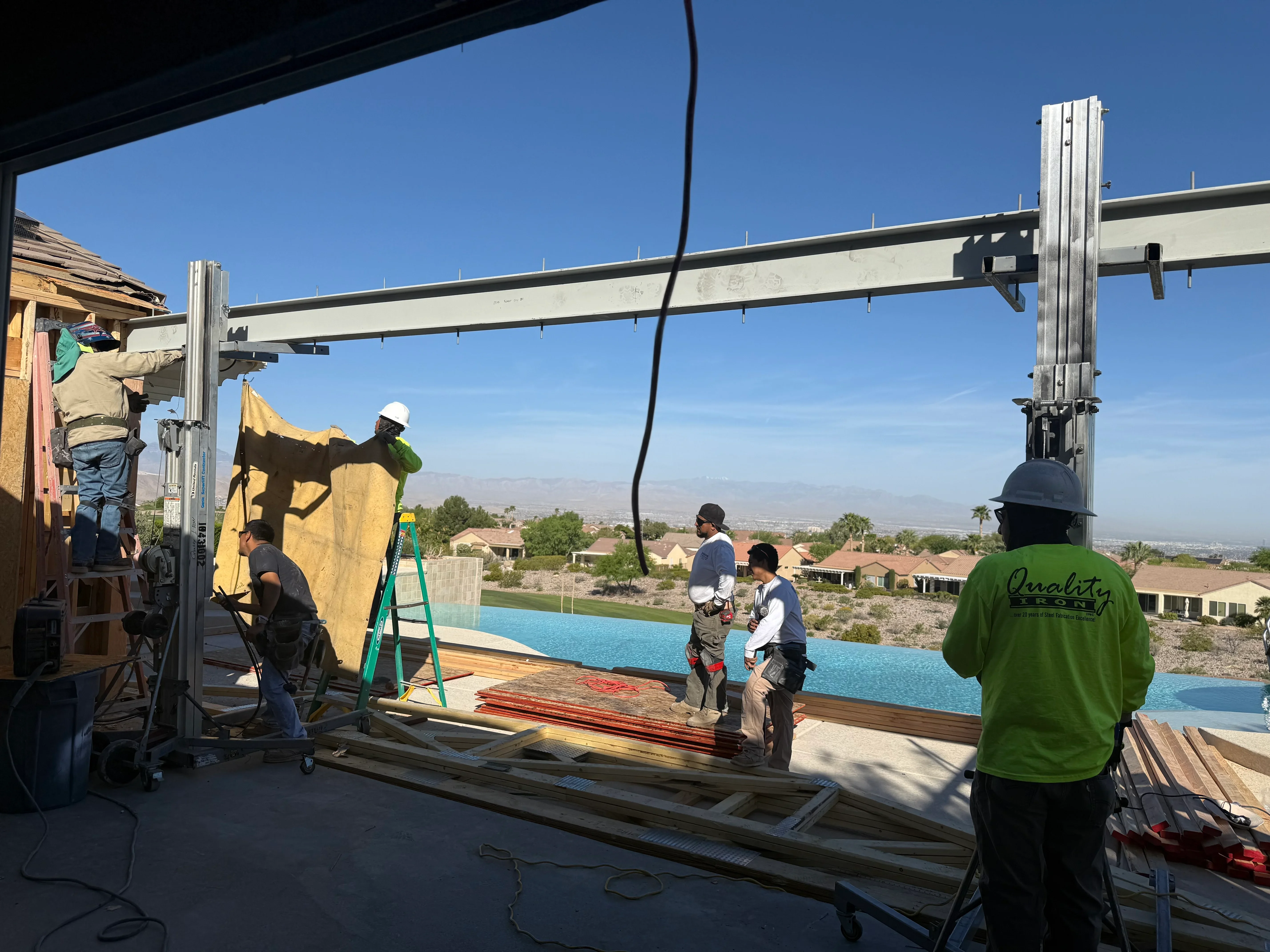 Aluminum pergola with motorized retractable shade being installed over pool patio area